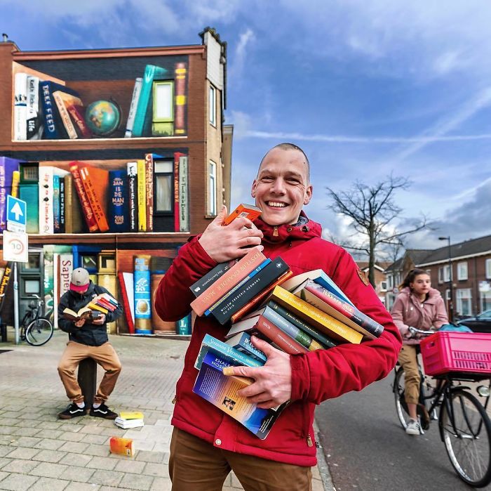 sensivel-mente.com - Artistas holandeses pintam estante gigante em um prédio de apartamentos com os livros favoritos dos moradores