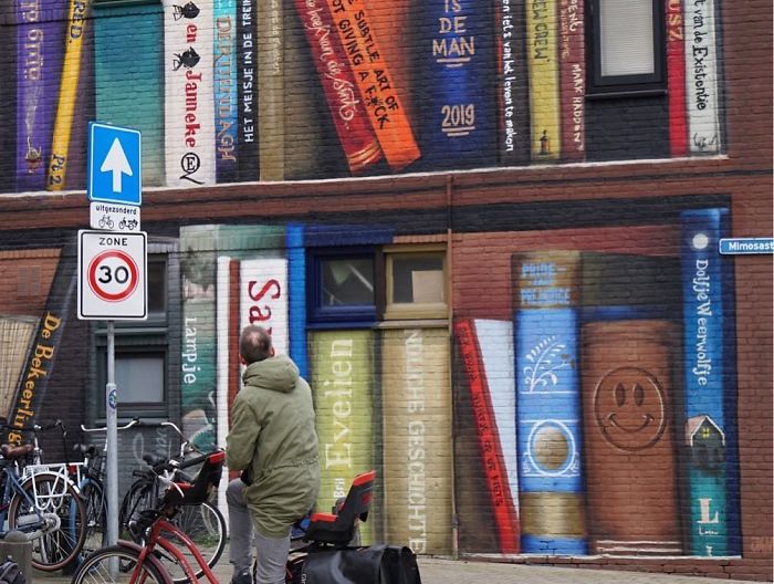 sensivel-mente.com - Artistas holandeses pintam estante gigante em um prédio de apartamentos com os livros favoritos dos moradores