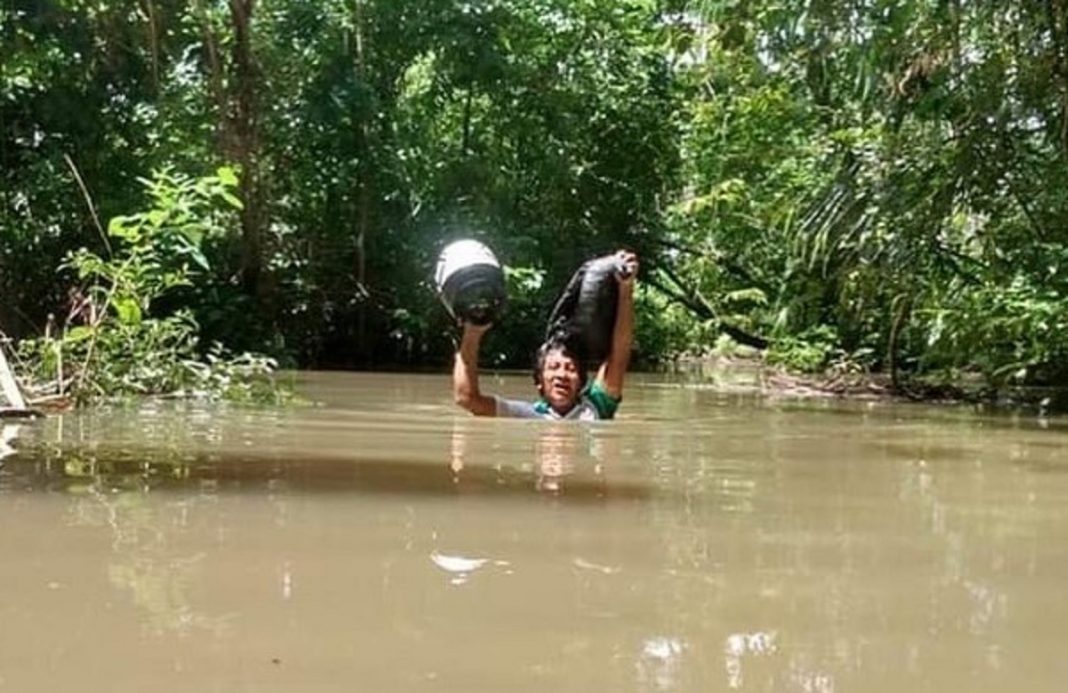 Professor caminha 30 Km e atravessa riacho com água pelo pescoço para imprimir material didático dos alunos indígenas em Roraima.